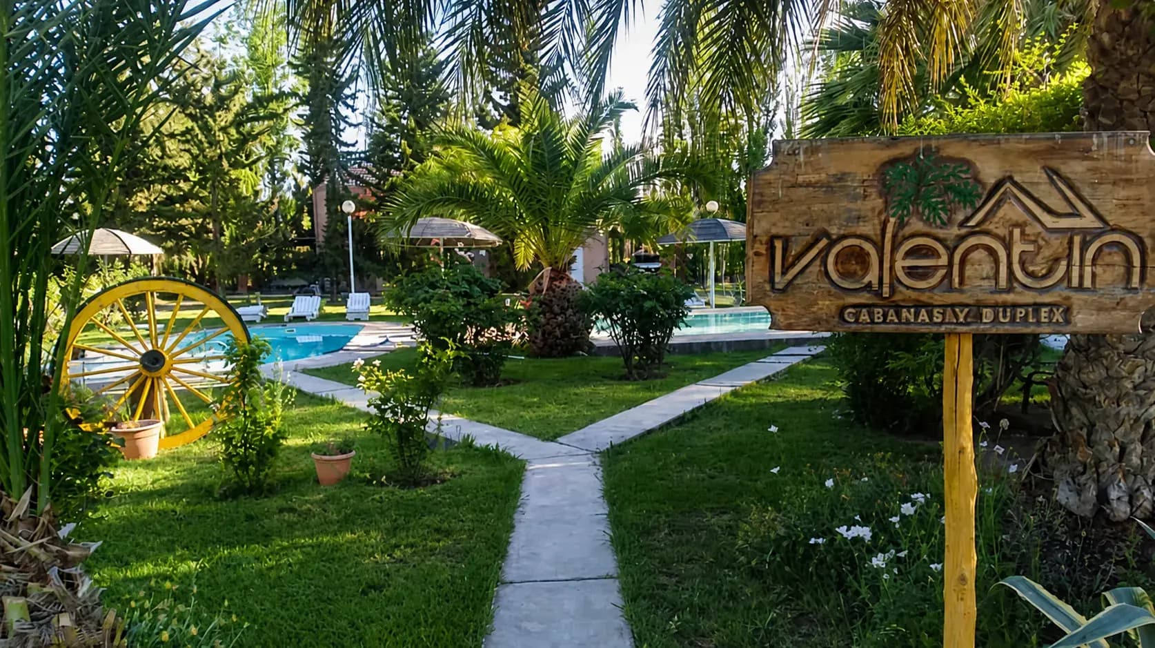 Ingreso, jardines y pileta de Complejo Valentín